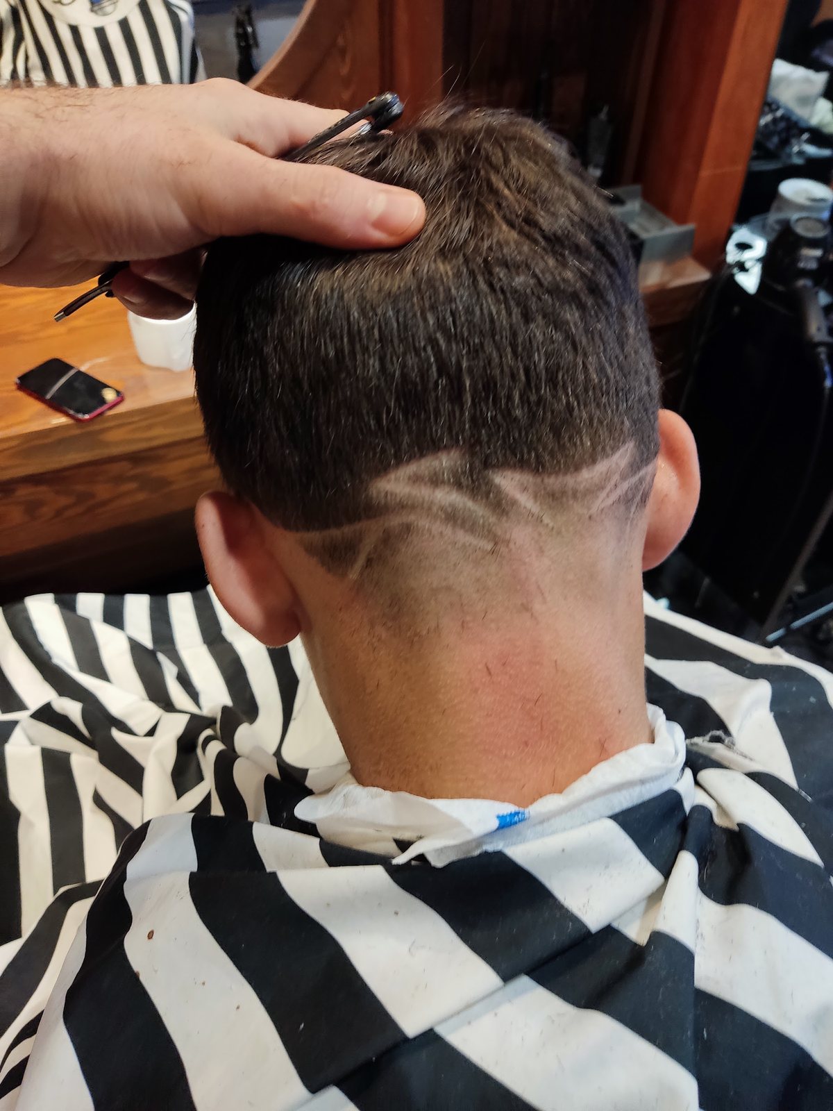 Patroon in het haar in de nek, met de hand van de kapper op het hoofd