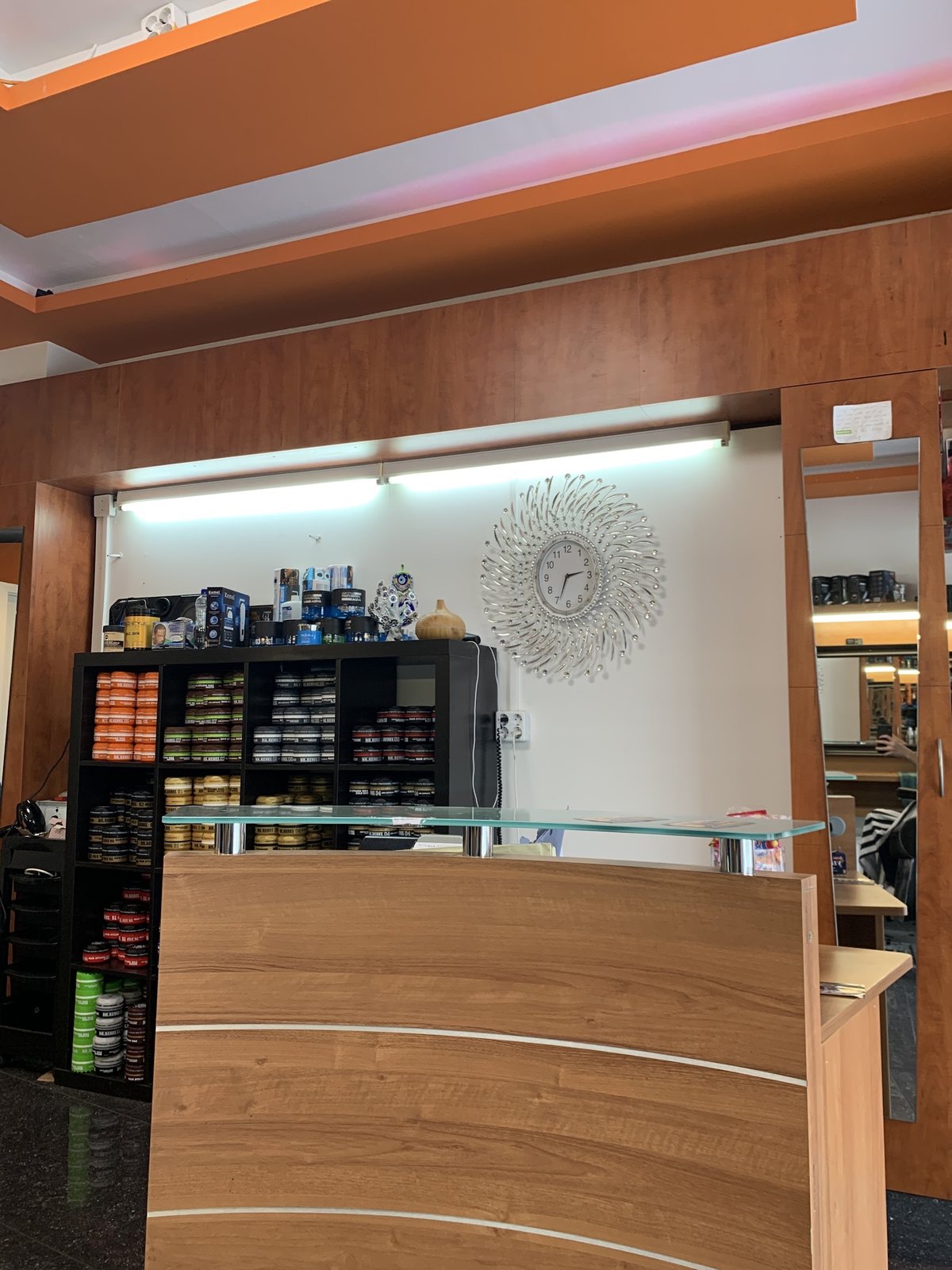 De toonbank van Kapsalon Seerwan met daarachter een kast vol haarproducten