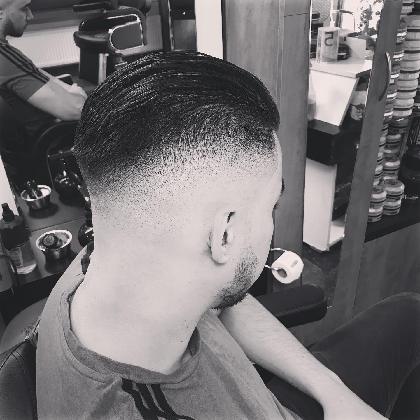 Zwart-witfoto van een fade met het haar naar achteren gekamd